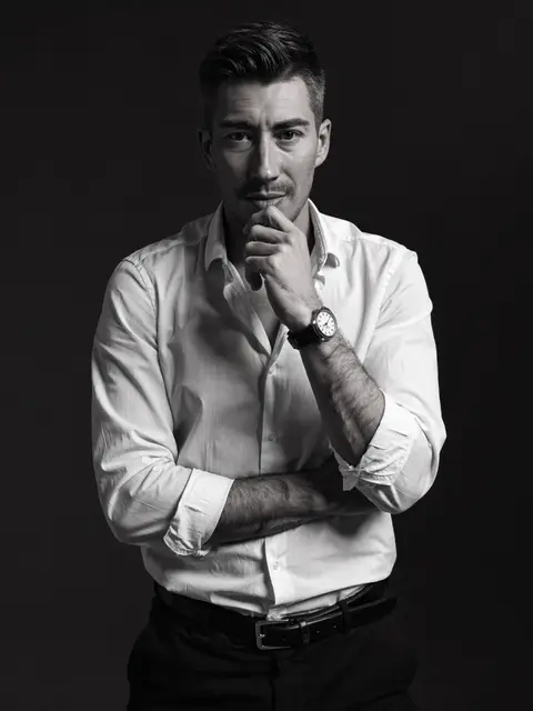 Jérémy Prost, en chemise blanche, la main au menton